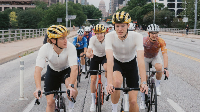 Un groupe de membres du Breakfast Club Austin font du vélo dans une rue de la ville.